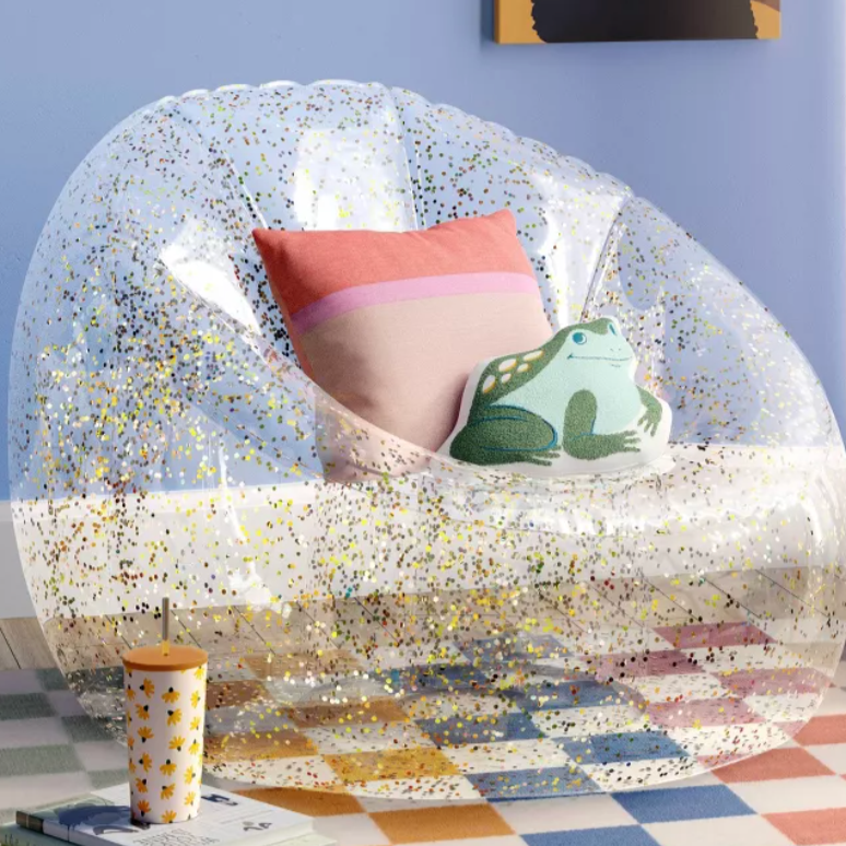 Clear inflatable glitter chair in a stylish indoor room setting, shimmering under soft lighting